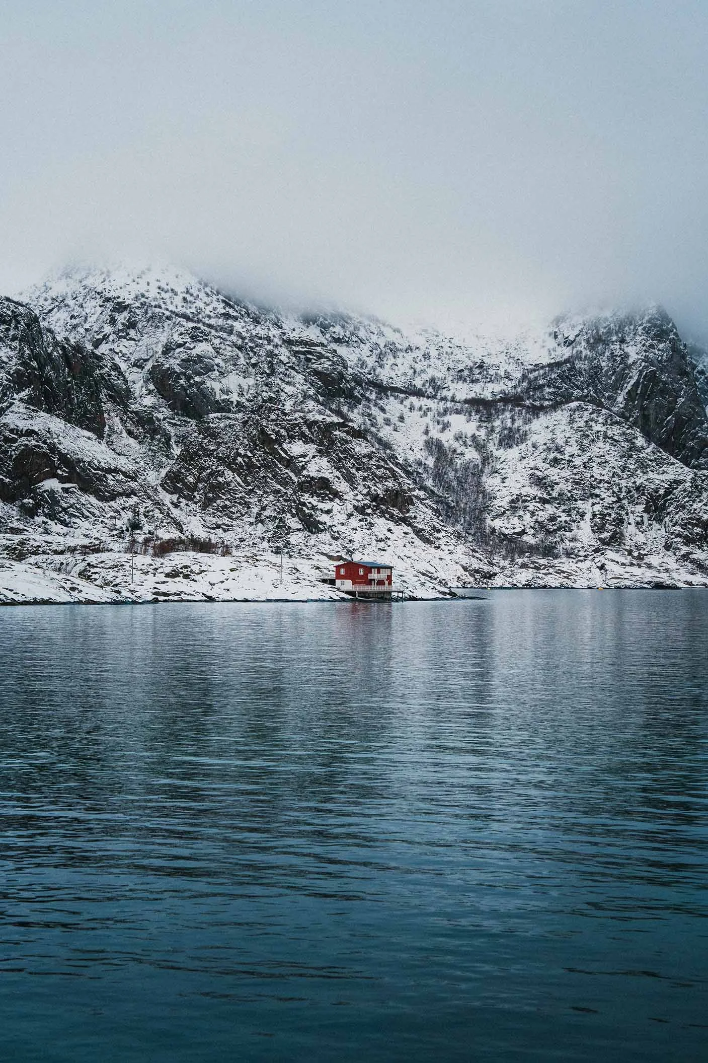 Fisherman red cabin in front of a lake.
